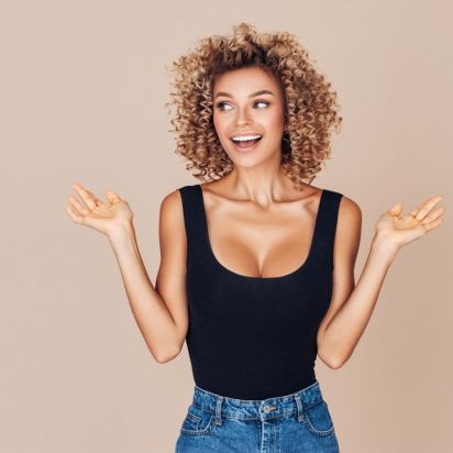 Blonde junge Frau happy nach ihrer Brustvergrößerung in München